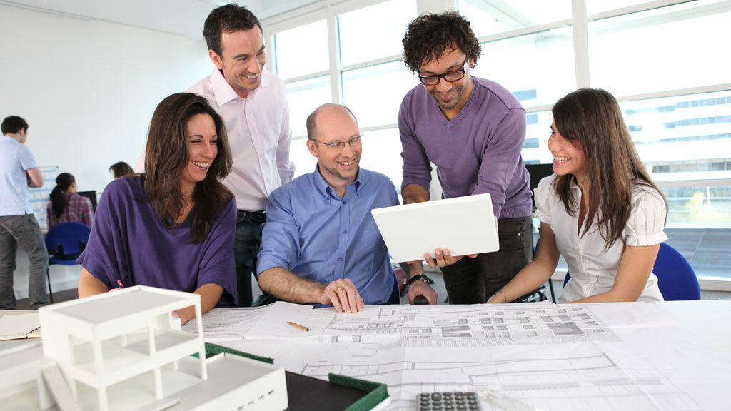 Conseillère immobilière en discussion avec un couple dans un salon lumineux pour un projet immobilier haut de gamme